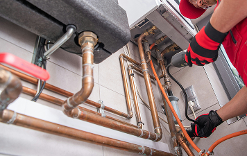 Worker installing copper plumbing pipes